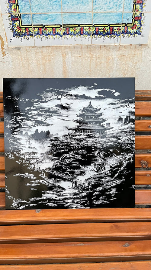 Tableau Temple Impérial en céramique gravée au laser, posé sur un banc en bois devant un mur en zellige