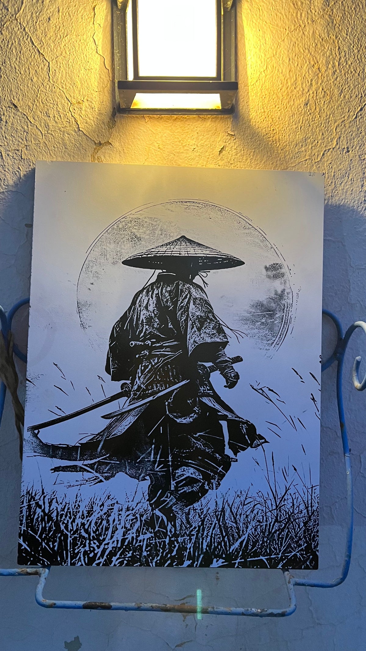 Carreau en céramique gravé au laser, motif samouraï, accroché à un mur et éclairé par une applique